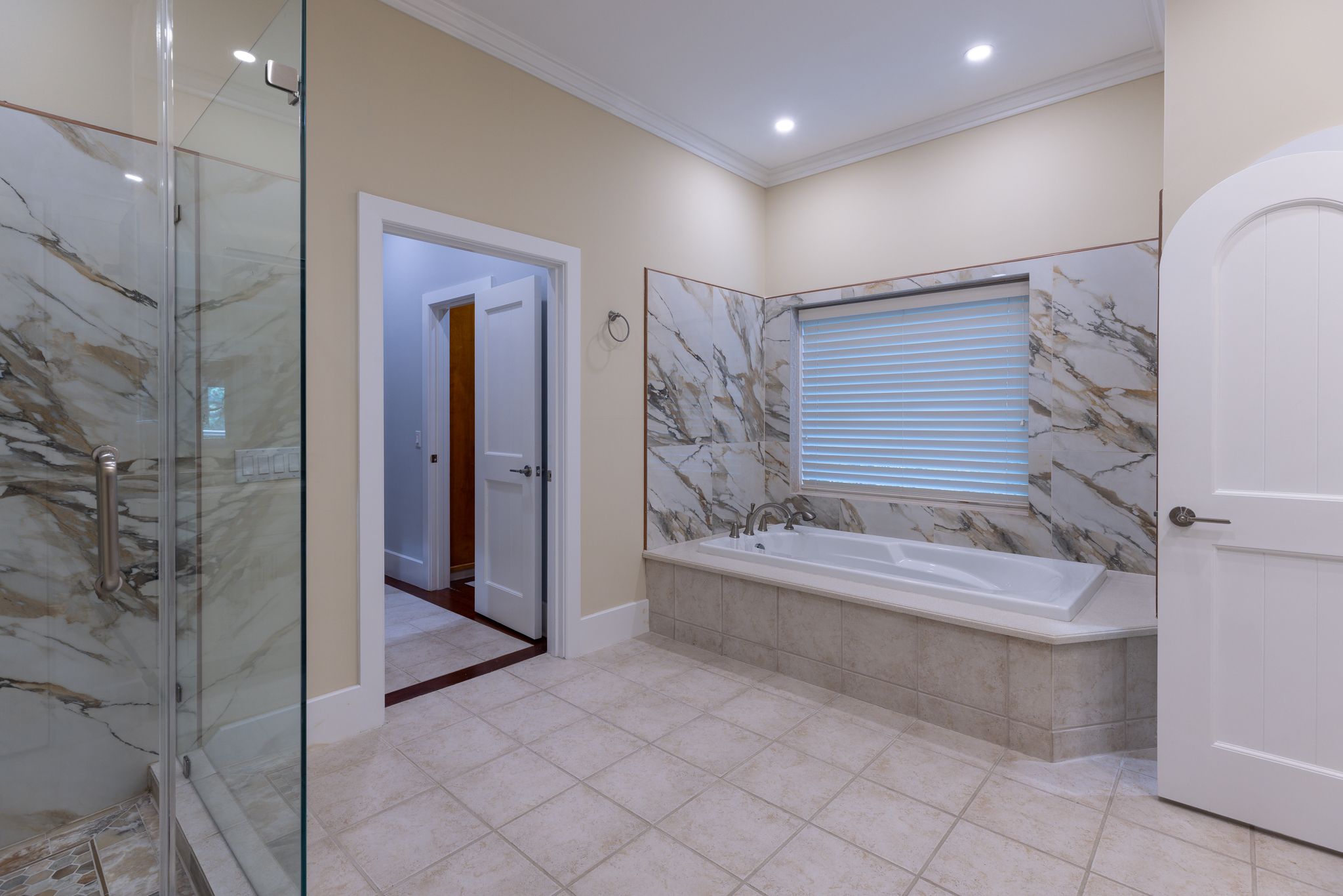 Marble primary bath with a freestanding soaking tub in a quiet suite at the estate