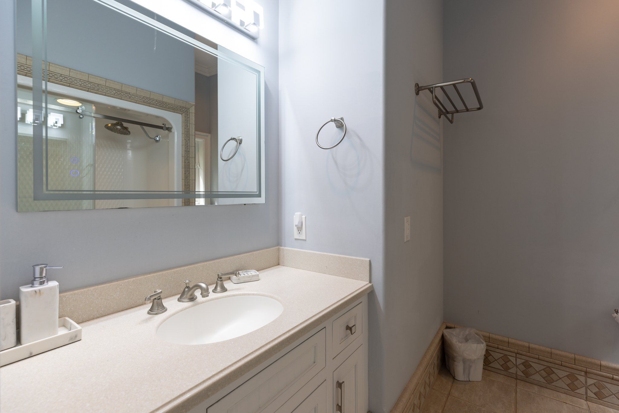 Suite bath vanity with a lit mirror and stone counter