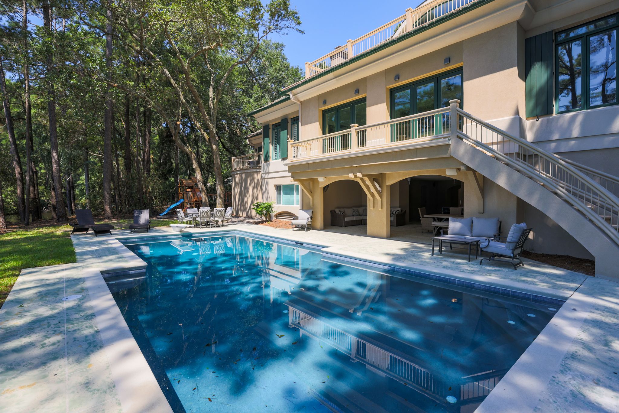 Private pool framed by the arched lanai of the Palmetto Dunes estate for the after-hours of an offsite