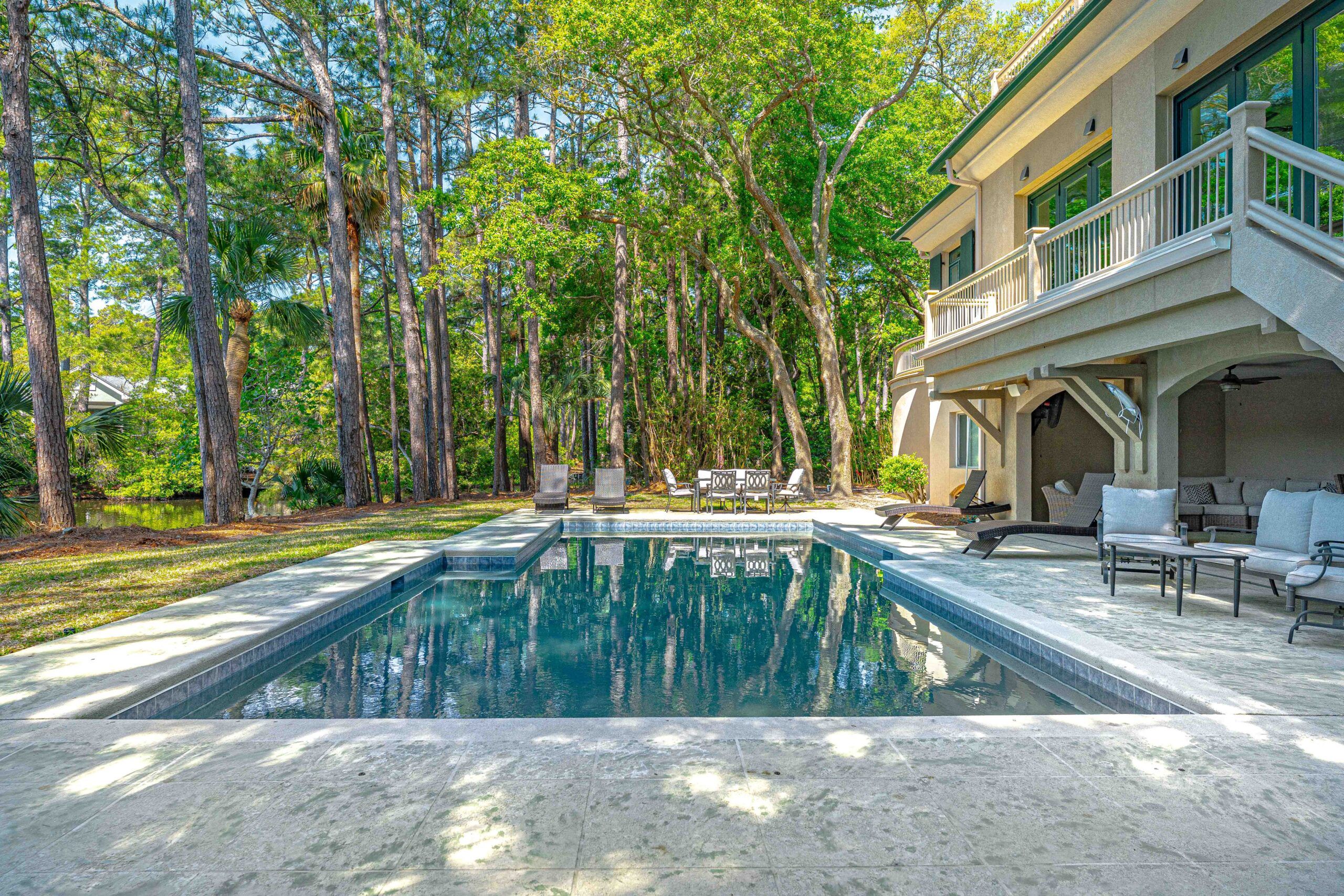 Private pool and travertine sun deck with loungers under the pines at the Hilton Head estate